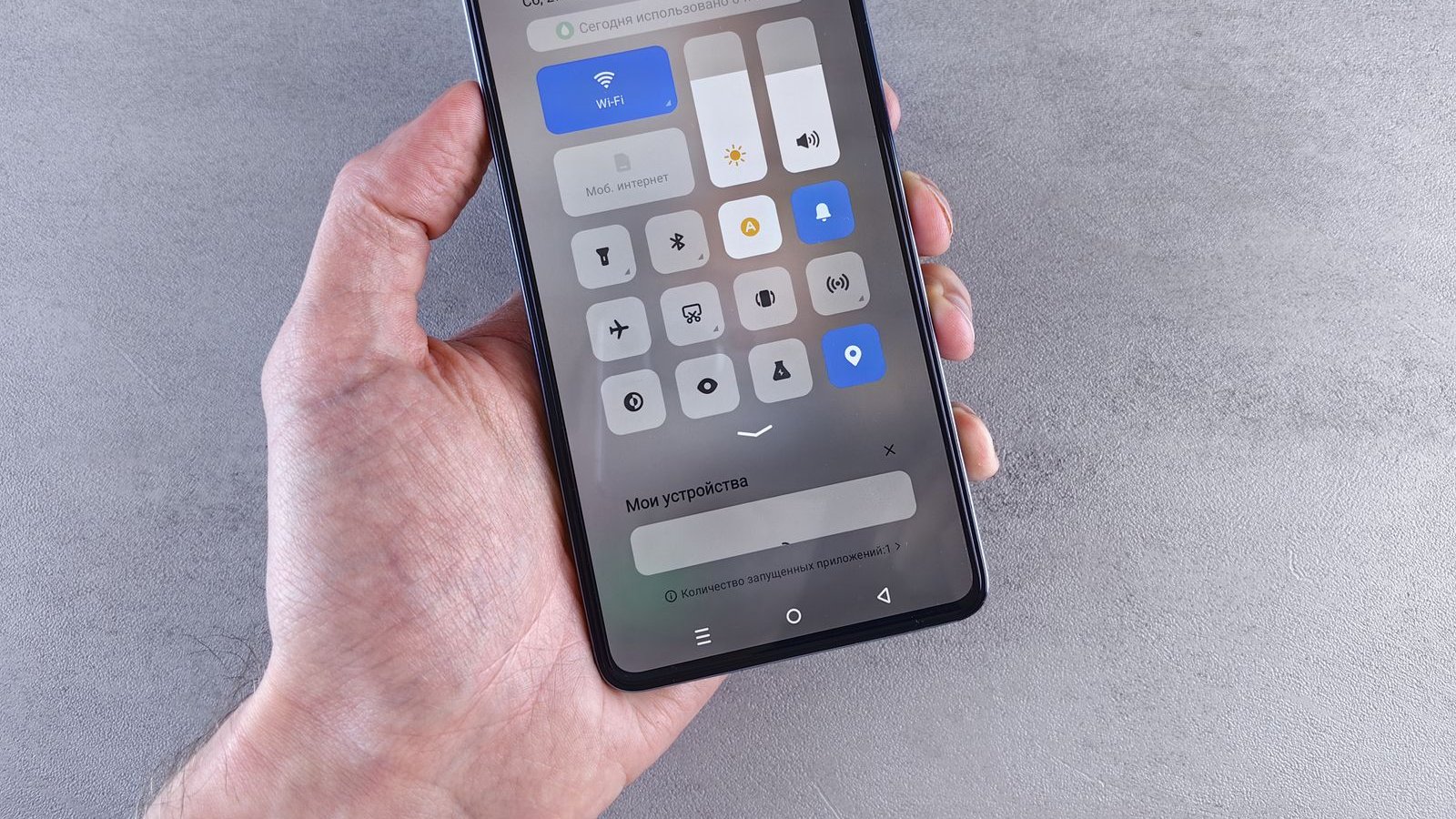Hand holding a smartphone with the settings menu displayed