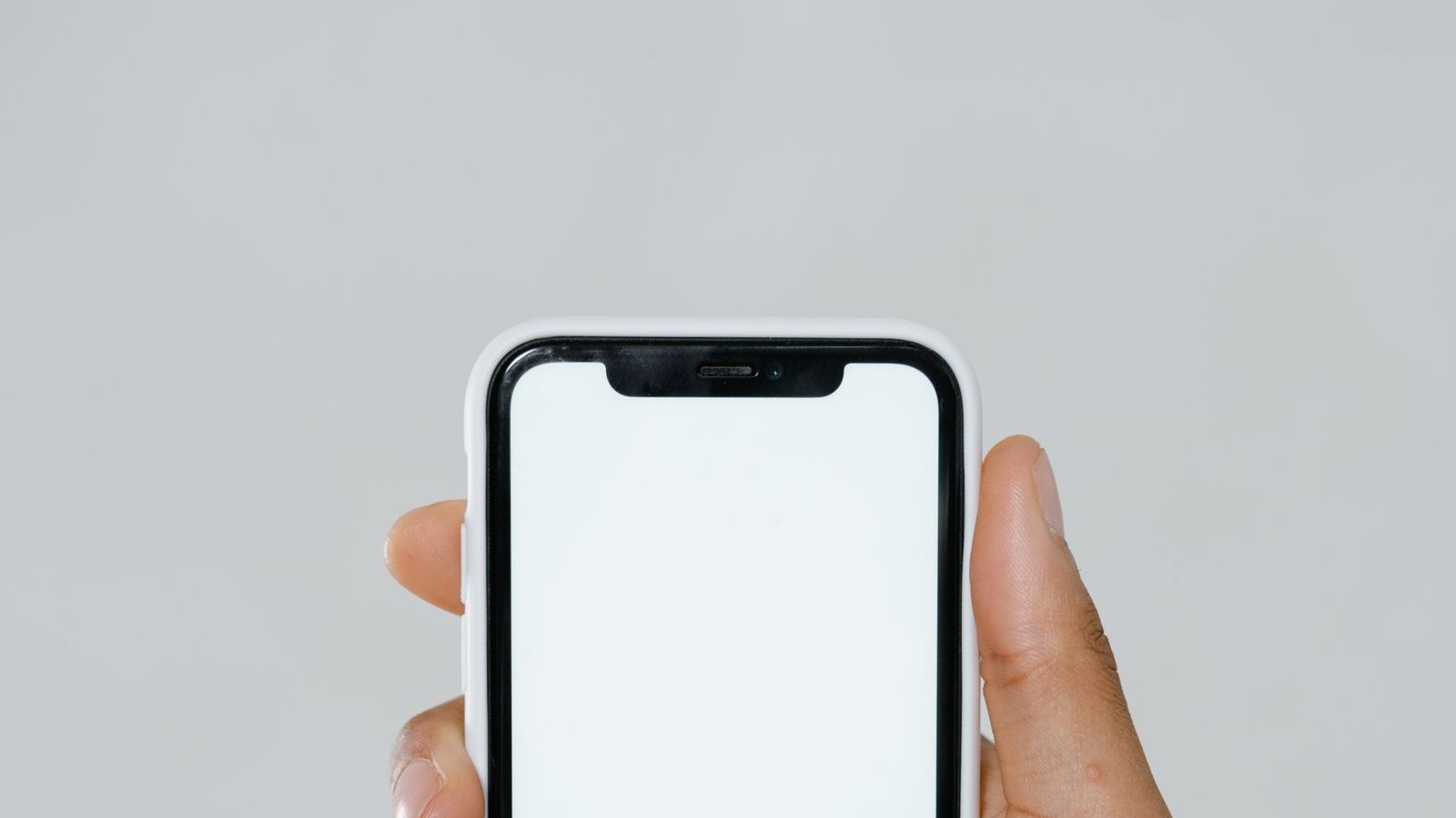Hand holding a smartphone displaying a home screen mockup