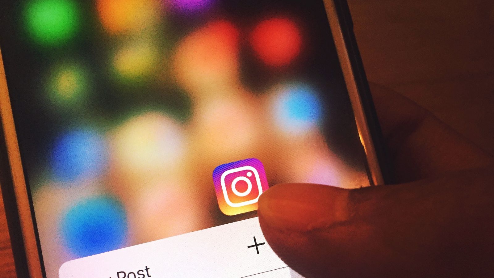 Finger navigating the Instagram app on a smartphone screen
