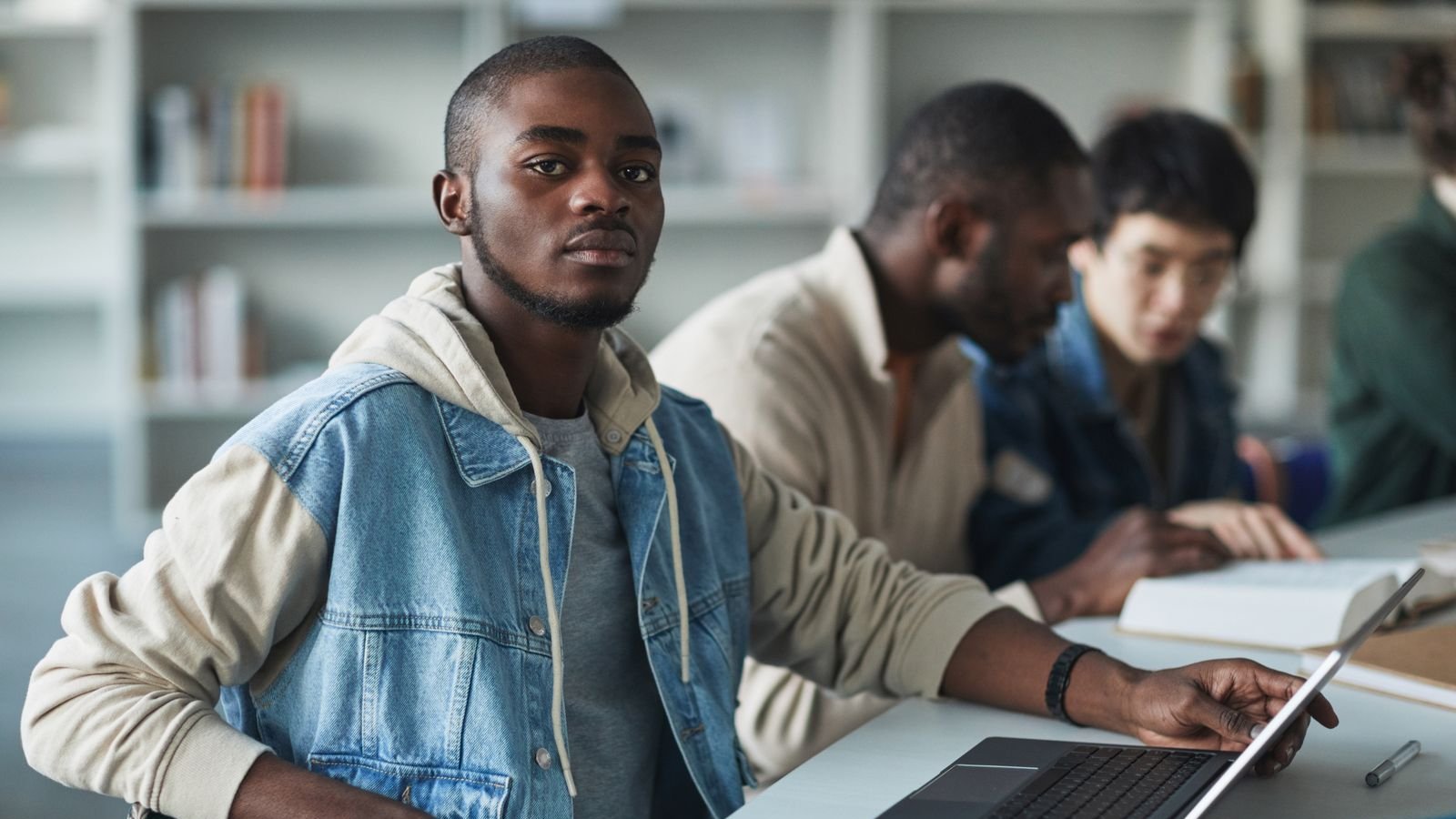 College student studying with a laptop in a busy setting