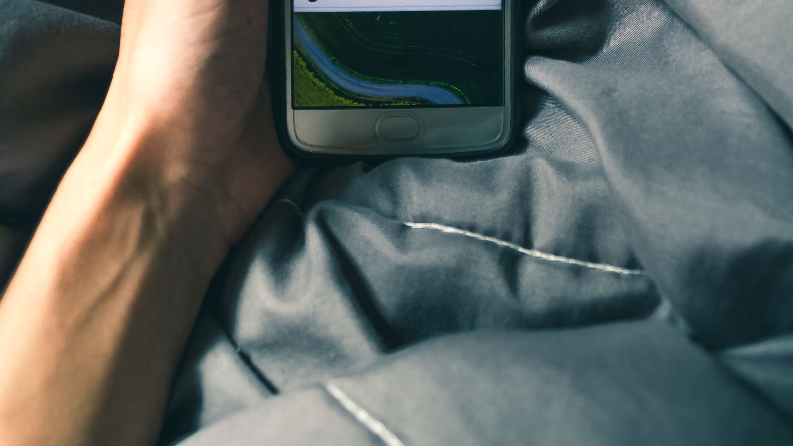 Close-up of a person holding a phone with a pensive expression